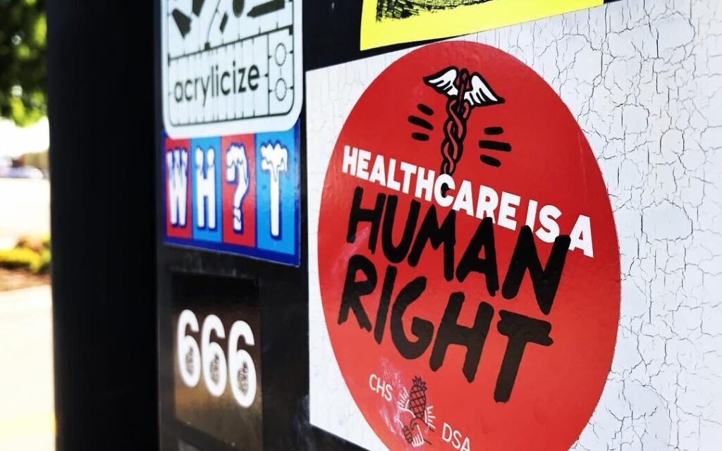 Closeup on a red sticker in the shape of a circle that reads 'Healthcare is a human right'